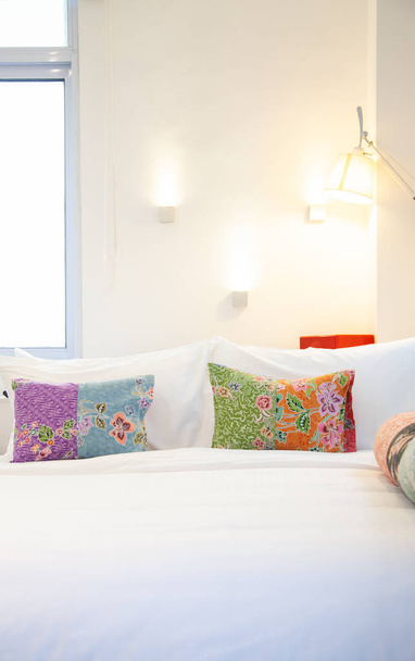 κρεβάτι με πολύχρωμα μαξιλάρια-φιλόξενο υπνοδωμάτιο - Φωτογραφία, εικόνα