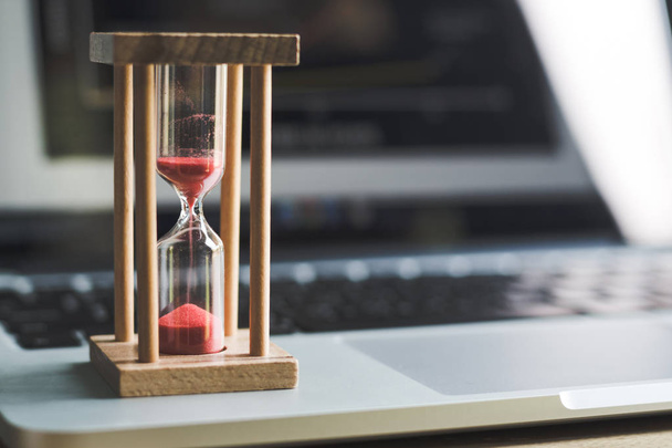 sand clock timer on laptop .symbol of time - Φωτογραφία, εικόνα