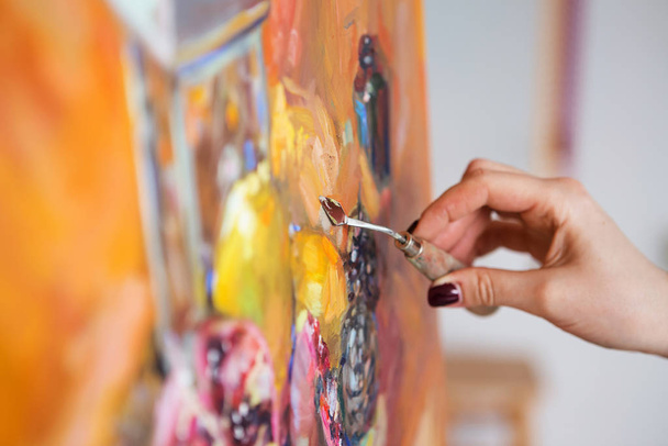 artist paints a picture of oil paint with palette-knife closeup - Foto, afbeelding