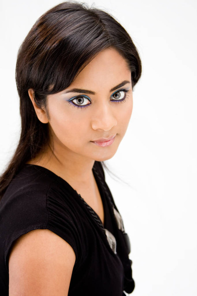 Face of a beautiful Hindi woman with subtle blue eye makeup and strong eyes, isolated - Fotó, kép