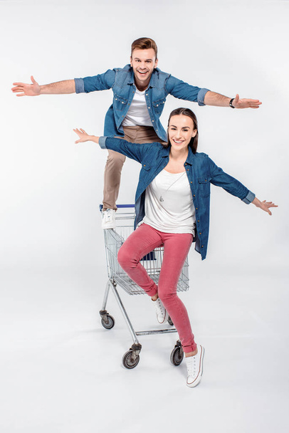 cheerful couple having fun on shopping cart - Fotó, kép