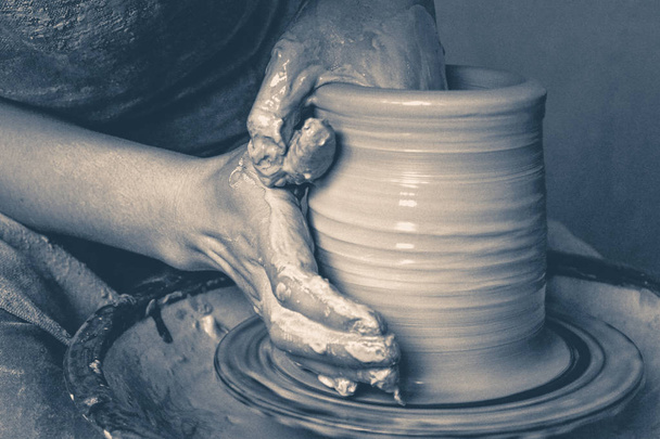 Photo in old vintage style. Creating a jar or vase of white clay close-up - Photo, Image
