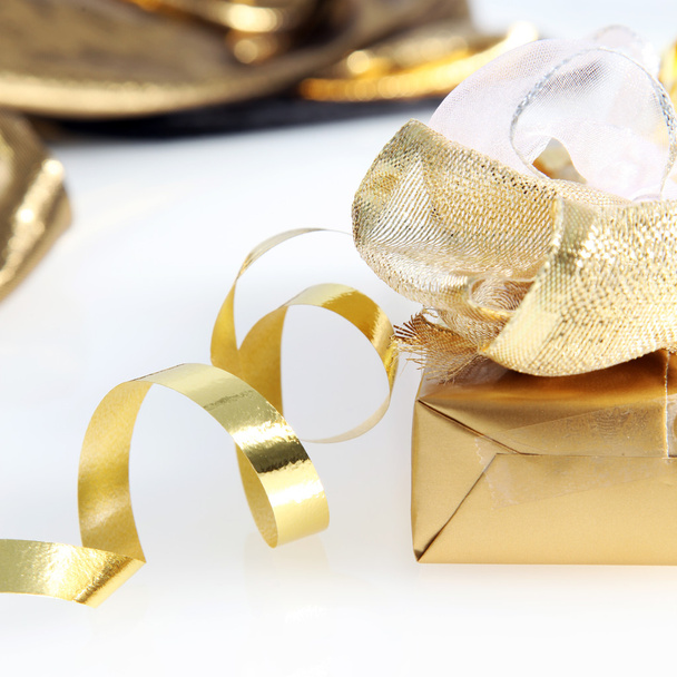 Pretty gold wrapped gift and twirled ribbon - Φωτογραφία, εικόνα