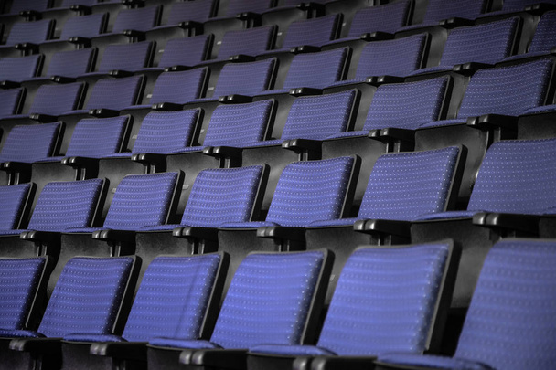 Вид с лестницы на ряды удобных синих стульев в театре или кинотеатре. Кривая синих сидений
 - Фото, изображение