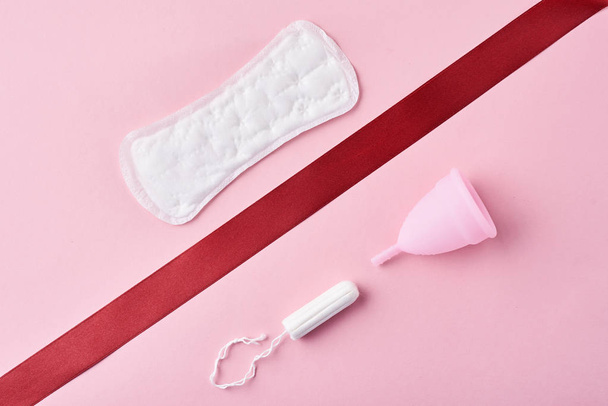 Sanitarnych pad, miesiączkowego kielich i tampon na różowym tle - Zdjęcie, obraz