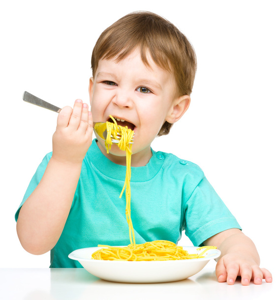 Little boy is eating spaghetti - Foto, afbeelding