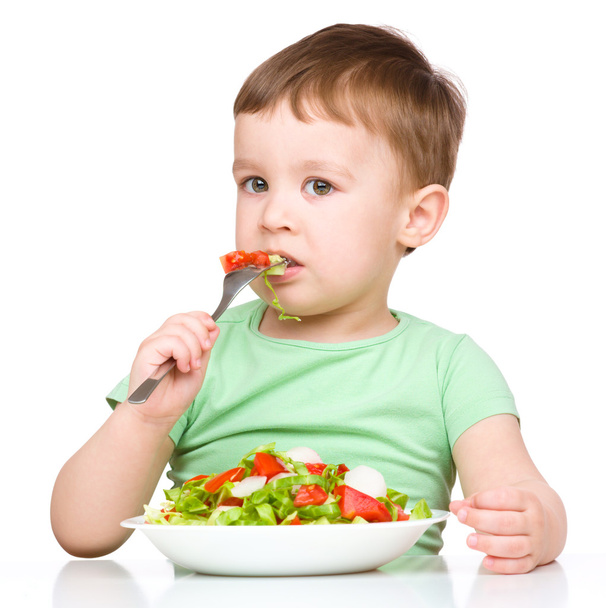 Cute little boy is eating vegetable salad - Foto, Imagem