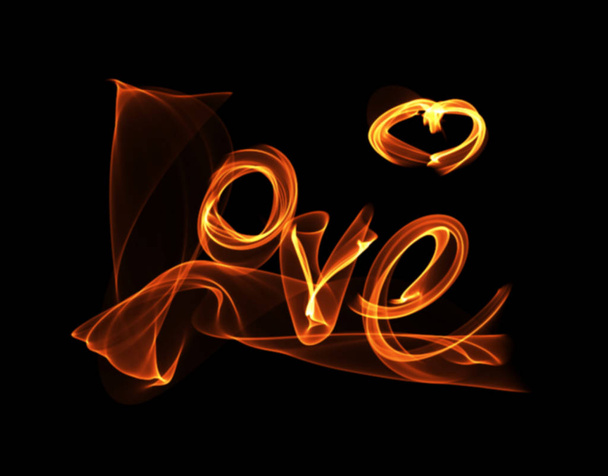 Love isolated word lettering and heart written with fire flame or smoke on black background. - Valokuva, kuva