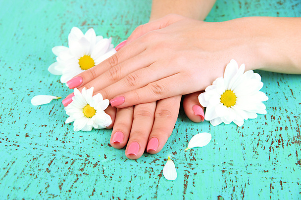 kobieta ręce z różowy manicure i kwiaty, na kolor tła - Zdjęcie, obraz