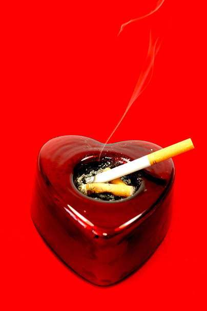 Cigarrillos en un cenicero en forma de corazón
 - Foto, imagen