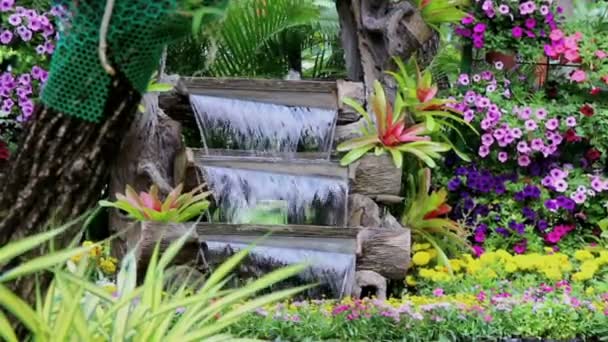 Footage waterfall flows and vivid flowers pot decoration in cozy home flower garden on summer. - Footage, Video