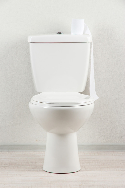 White toilet bowl with toilet paper in a bathroom - Фото, изображение