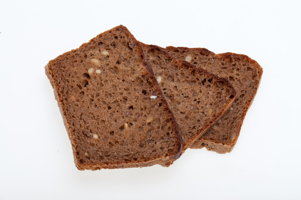 Кусочки черного хлеба, изолированные поверх белого
 - Фото, изображение