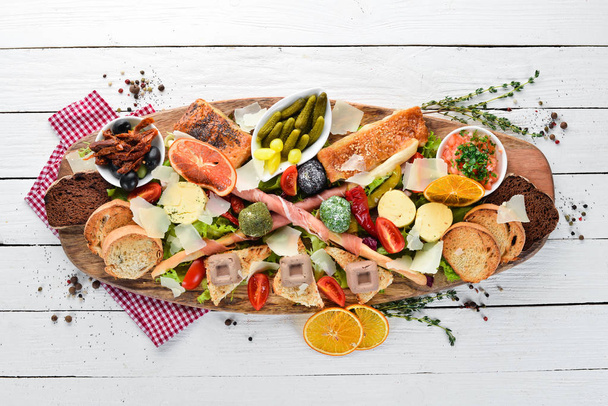 A set of food. Snacks of Italian cuisine. On a wooden background. Top view. Free copy space - Fotoğraf, Görsel