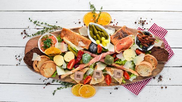 A set of food. Snacks of Italian cuisine. On a wooden background. Top view. Free copy space - Φωτογραφία, εικόνα