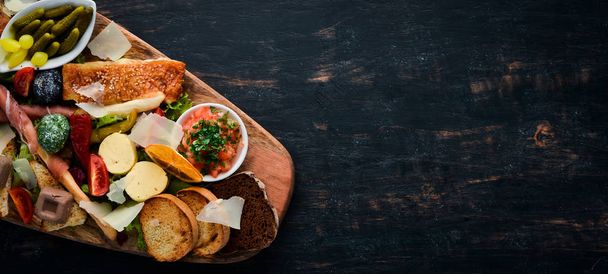 A set of food. Snacks of Italian cuisine. On a wooden background. Top view. Free copy space - Fotoğraf, Görsel