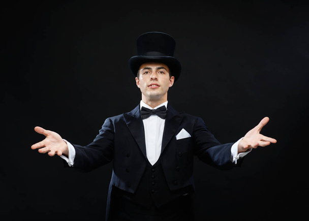 magic, performance, circus, show concept - magician in top hat showing trick - Fotó, kép