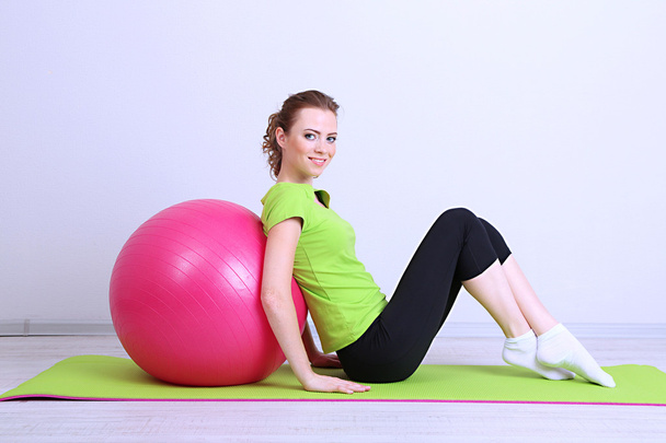 Portrait of beautiful young woman exercises with gym ball - Valokuva, kuva