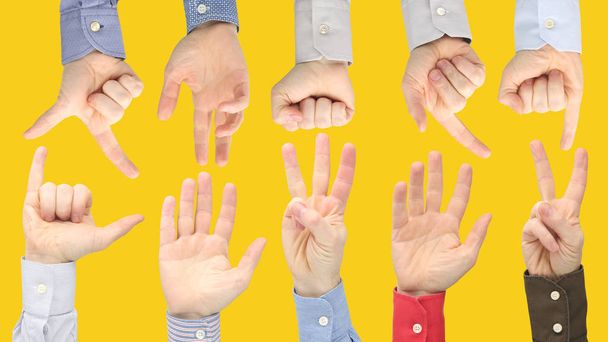 Verschillende gebaren van mannelijke handen tussen elkaar op een gele ba - Foto, afbeelding