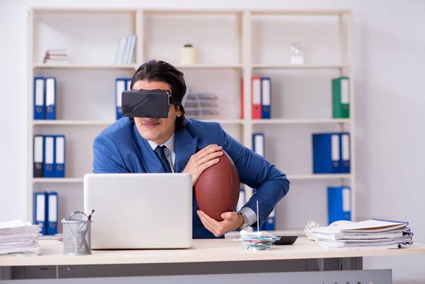Jeune homme d'affaires beau jouant au rugby avec des lunettes virtuelles
 - Photo, image