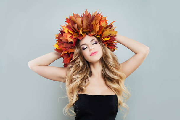 Autumn woman wearing colorful fall leaves crown on gray background - Φωτογραφία, εικόνα