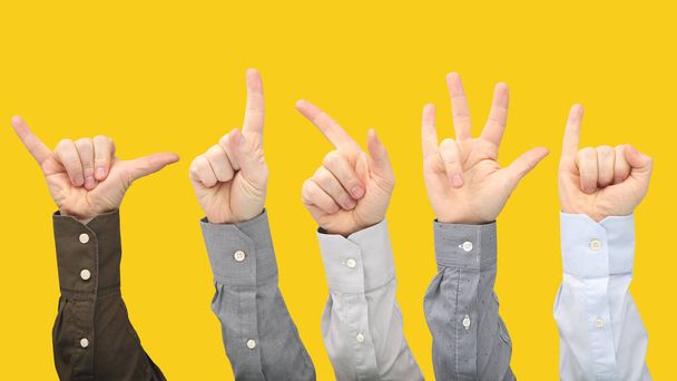 Vari gesti di mani maschili tra di loro su una ba gialla
 - Foto, immagini