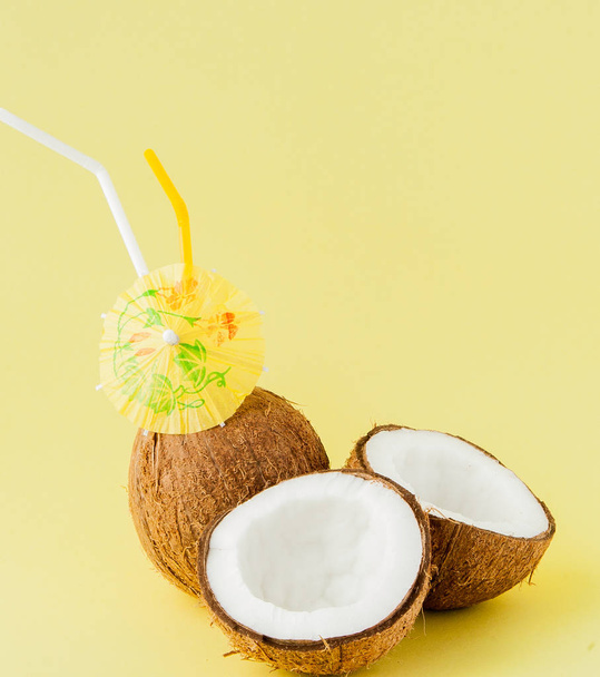 Fresh Coconut cocktail with a straws on yellow background, copy space - Foto, Bild