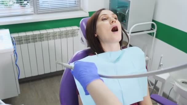 Mujer joven en examen preventivo en silla dental en el dentista. Concepto de cuidado dental
. - Imágenes, Vídeo