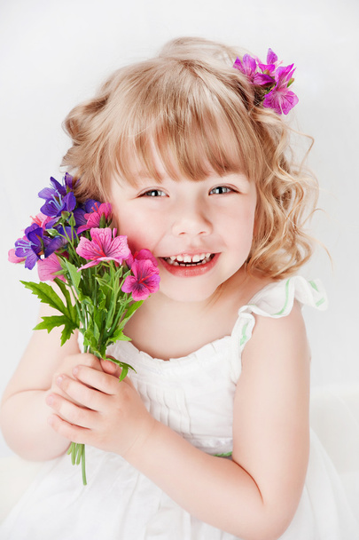 Girl with a bouquet of flowers, on a gray background - Photo, image