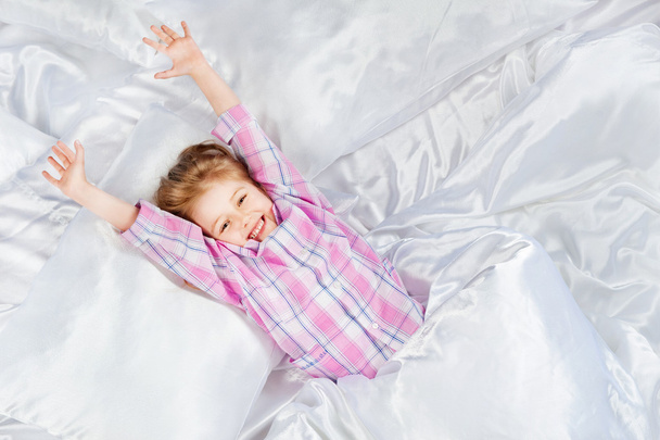 Little girl stretches in bed - Фото, зображення