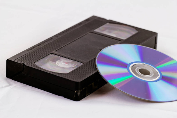 VHS video tape and DVD disk (analog digital) on white background - Foto, afbeelding