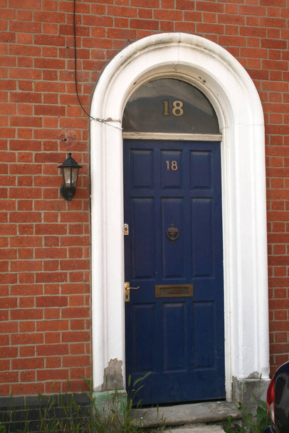 blue door in a arched doorway with glass above the door - Photo, image