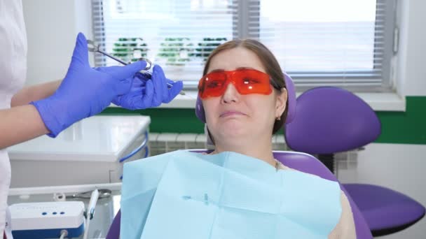 Portrét mladé ženy, která se bojí odstranit zub sedící na zubním křesle - Záběry, video