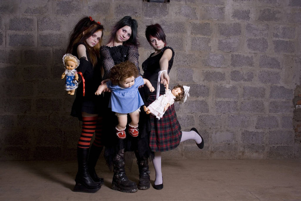 Sad, gloomy girls hold in hands of dolls - Zdjęcie, obraz