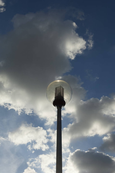 Modern spherical street light against a cloudy dramatic blue sky - Fotoğraf, Görsel