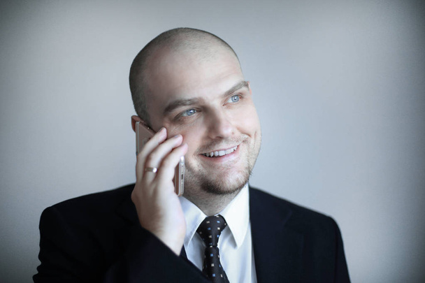 confident businessman in a tie listens to the interlocutor on the phone. - Photo, image