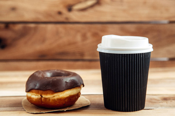 frischer handwerklicher Donut und Kaffee zum Mitnehmen, Holzhintergrund mit Kopierraum - Foto, Bild