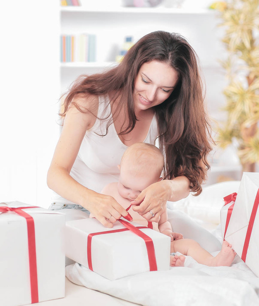 young mother unties the ribbon on the gift boxes - Photo, Image