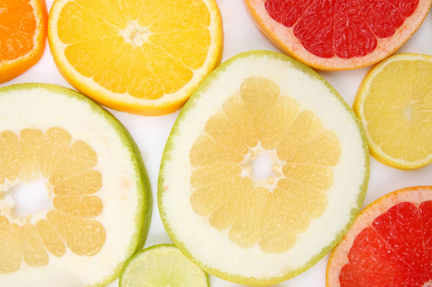 cut pieces of different citrus fruits on white background - Foto, Imagen