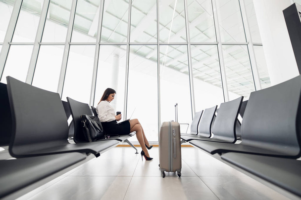 Młoda pasażerka na lotnisku, korzystająca z tabletu w oczekiwaniu na lot - Zdjęcie, obraz
