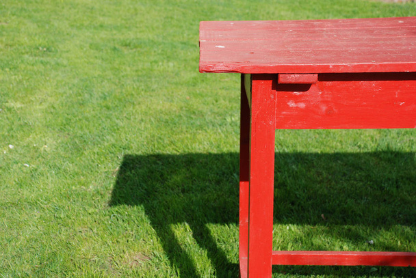Self made table of planks coloured red standing on the green grass - Valokuva, kuva