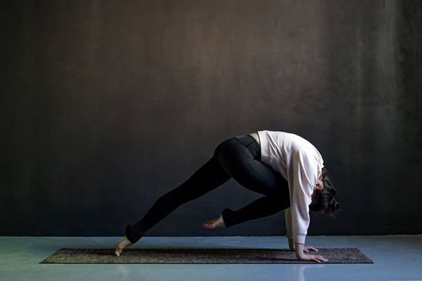 Jeune femme pratiquant le yoga, faisant asana Marjaryasana pose, travaillant
 - Photo, image