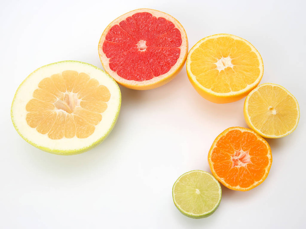 cut pieces of different citrus fruits on white background - Fotó, kép