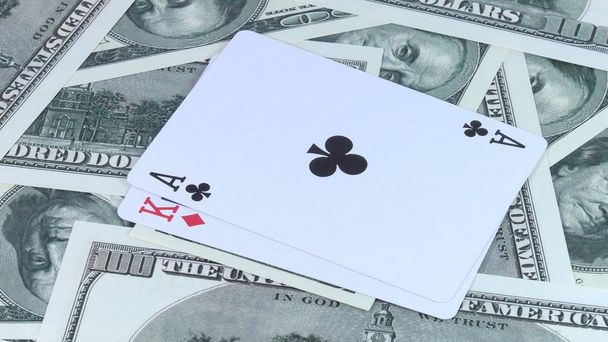 Rotating background from money of US dollars and a combination of two-double cards it is in poker close-up. - Photo, Image
