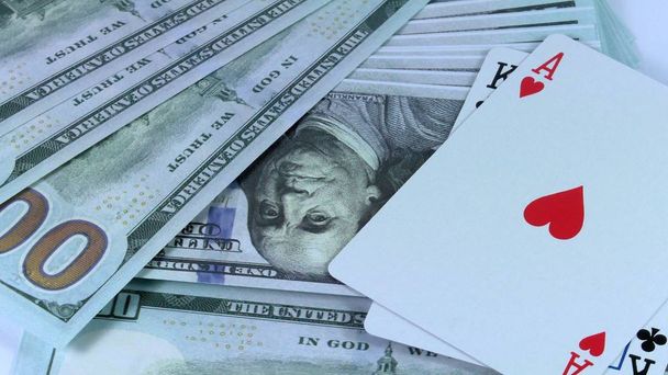 Fondo giratorio de dinero de dólares estadounidenses y una combinación de dos tarjetas dobles que está en primer plano de poker
. - Foto, imagen