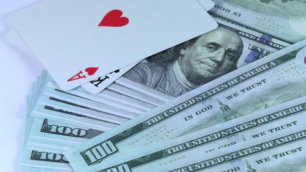 Obracanie tła z pieniędzy z dolarów amerykańskich i połączenie dwóch podwójnych kart jest w pokera zbliżenie. - Zdjęcie, obraz