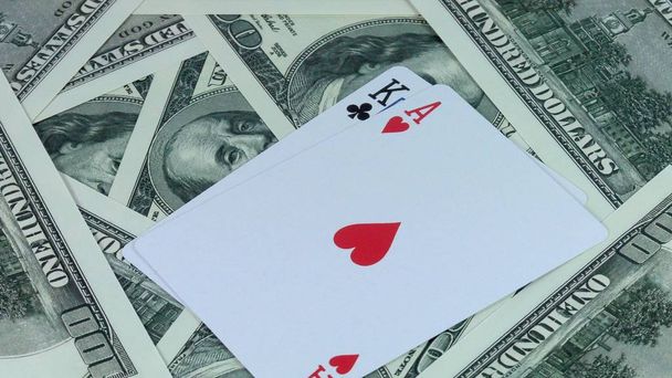 rotierenden Hintergrund aus Geld von uns Dollars und einer Kombination aus zwei doppelten Karten ist es im Poker Nahaufnahme. - Foto, Bild
