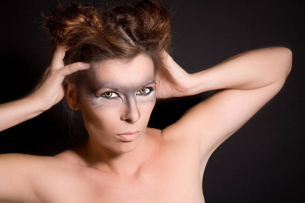 Beautiful woman with wolf eyes and intense look on black background - Valokuva, kuva
