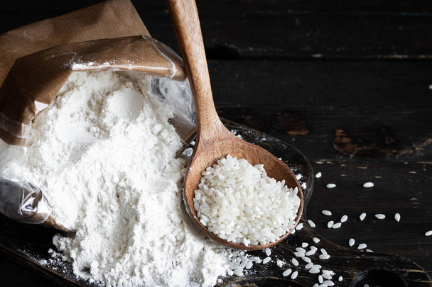 White rice flour in a crafting bag on a dark wooden background - Fotografie, Obrázek