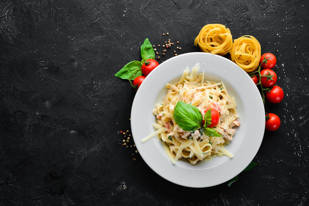 Pasta with bacon and cherry tomatoes. Italian dish. Free space for your text. Top view. - Fotografie, Obrázek